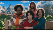 a group of people standing next to each other with a mountain in the background