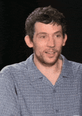 a man with a beard wearing a blue plaid shirt