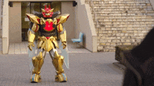 a robot with wings and a red head is standing in front of a building