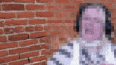 a pixelated image of a person standing in front of a red brick wall