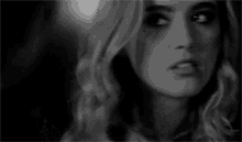 a black and white photo of a woman 's face with a serious look on her face .