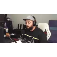 a man wearing a hat and headphones is sitting at a desk
