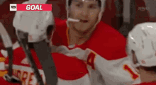 a hockey player is smoking a cigarette while sitting on the bench .