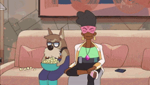 a dog is sitting on a couch with a bowl of popcorn