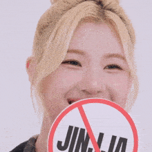 a woman holds a sign that says jinja in front of her face