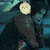 a drawing of a rabbit with a face on it is on a person 's shoulder