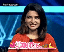 a woman in a red sweater is smiling with the word black in pink