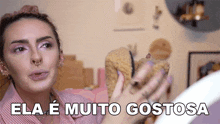 a woman is holding a pair of shoes with the words ela e muito gostosa above her