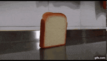 a slice of bread is sitting on a counter in front of a wall .
