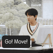a man sitting at a desk with a sign that says go move on it