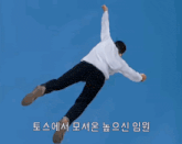 a man in a white shirt is giving a thumbs up in front of a blue background