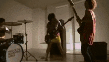 a group of people are playing instruments in a room with a drum set that says mass of the fermenting dregs