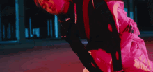 a person in a pink and black outfit is laying on the ground