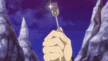 a person is holding a key in their hand in front of mountains