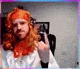 a man with red hair and a beard giving the middle finger