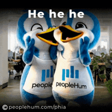 two penguin mascots wearing peoplehum shirts are laughing together