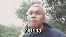 a man wearing a blue shirt has a foreign language written on his face