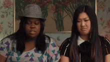 two women are sitting next to each other and one has purple hair