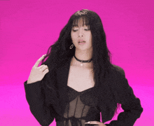 a woman with long black hair wearing a choker and a black jacket