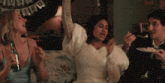 a woman in a white dress is dancing in front of a banner that says " married "