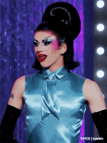 a drag queen is wearing a blue satin top
