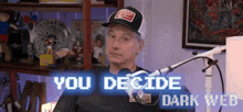 a man wearing a hat is sitting in front of a microphone with the words `` you decide dark web '' displayed .