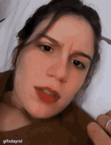 a close up of a woman 's face with the words gifsdayrol at the bottom