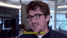 a man wearing glasses and a mustache is smiling and says gostoso , ne ?