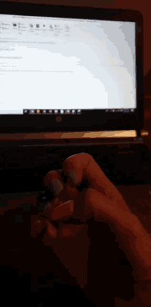 a close up of a person 's hand in front of a laptop