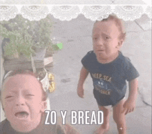 two babies are crying and one of them is wearing a shirt that says explorer .