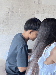 a boy and a girl are kissing in front of a wall with newspapers on it