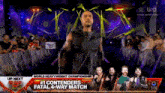 a man is standing in front of a crowd with a sign that says " # 1 contenders fatal 4 way match "