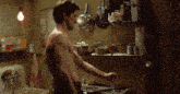 a man without a shirt is standing in a kitchen with a box of kraft macaroni and cheese in the background