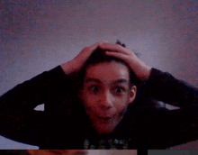 a boy with his hands on his head making a funny face