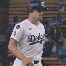 a man wearing a dodgers jersey and helmet