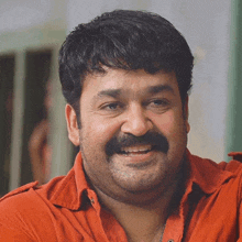 a man with a mustache and a red shirt smiles