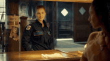 a woman in a police uniform is standing in front of a mirror