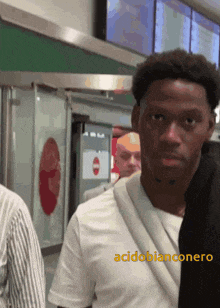 a man in a white shirt with the word acidobianconero on the bottom