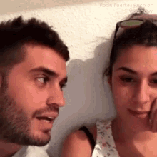 a man and a woman are looking at each other while sitting next to each other .