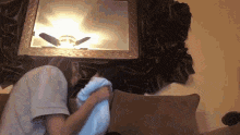 a man and woman are hugging on a couch with a mirror in the background