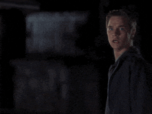 a man with a surprised look on his face stands in front of a red light