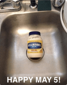 a bottle of hellmann 's real mayonnaise sits in a sink