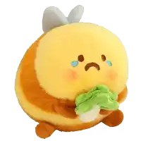 a stuffed bee with a sad face is holding a green leaf