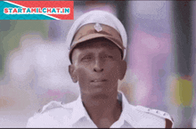 a man in a police uniform stands in front of a starttamilchat.in banner