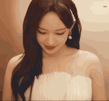 a woman in a white dress with pearls on her hair
