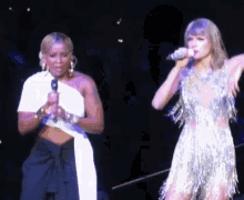 a woman singing into a microphone while another woman stands behind her