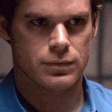 a man in a blue shirt looks at the camera