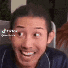 a man is smiling and making a funny face while looking at the camera .