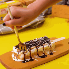 a person is holding a fork over a piece of cake on a cutting board with a box in the background that says 30 %