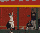 a baseball player with the letter a on his hat catches a ball